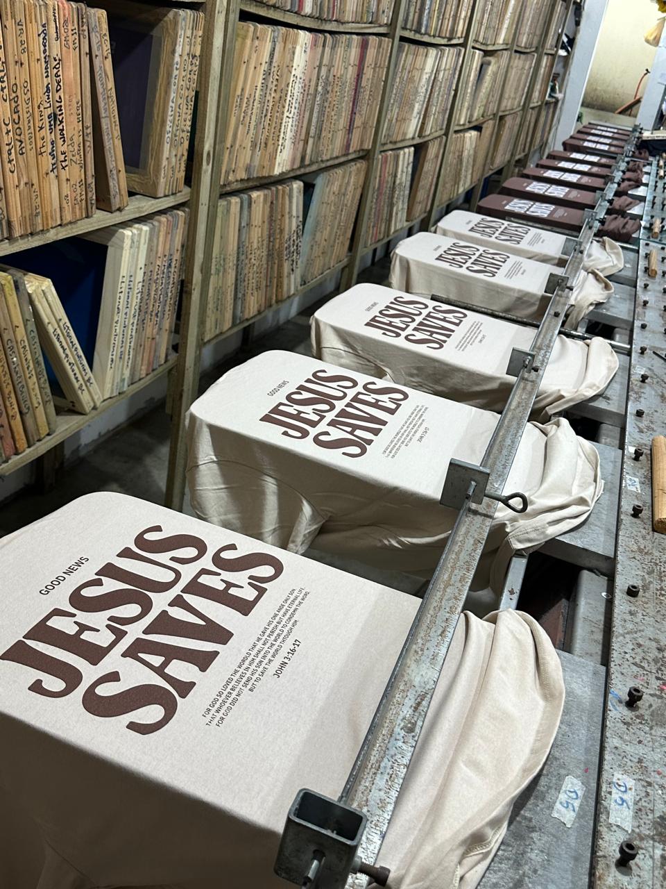 Camisetas evangelicas com estampa 'JESUS SAVES' em linha de produção