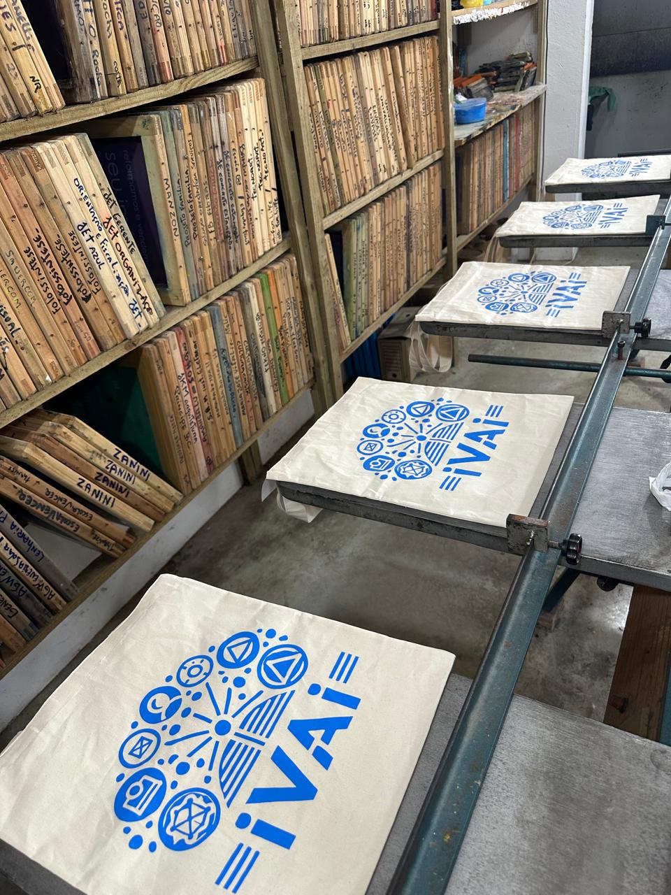 Ecobags com estampa azul de símbolos em processo de produção